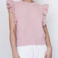 Person wearing a pink knitted top with ruffled sleeves on a white background